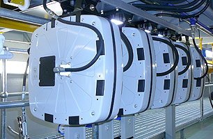 Encased lubrication hose reels mounted to roof of suspended ceiling workshop pit, reels shown include reel enclosures