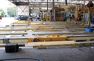 Layout steel work to carry the jacking system and locate jack runs on the workshop pit wall and secure to wall or structure